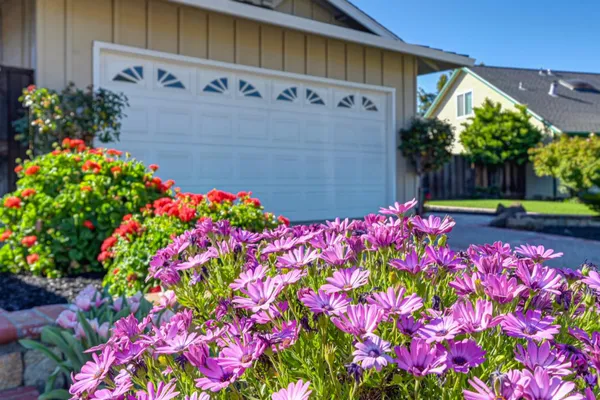 a view of an empty room with wooden floor and a bathroom