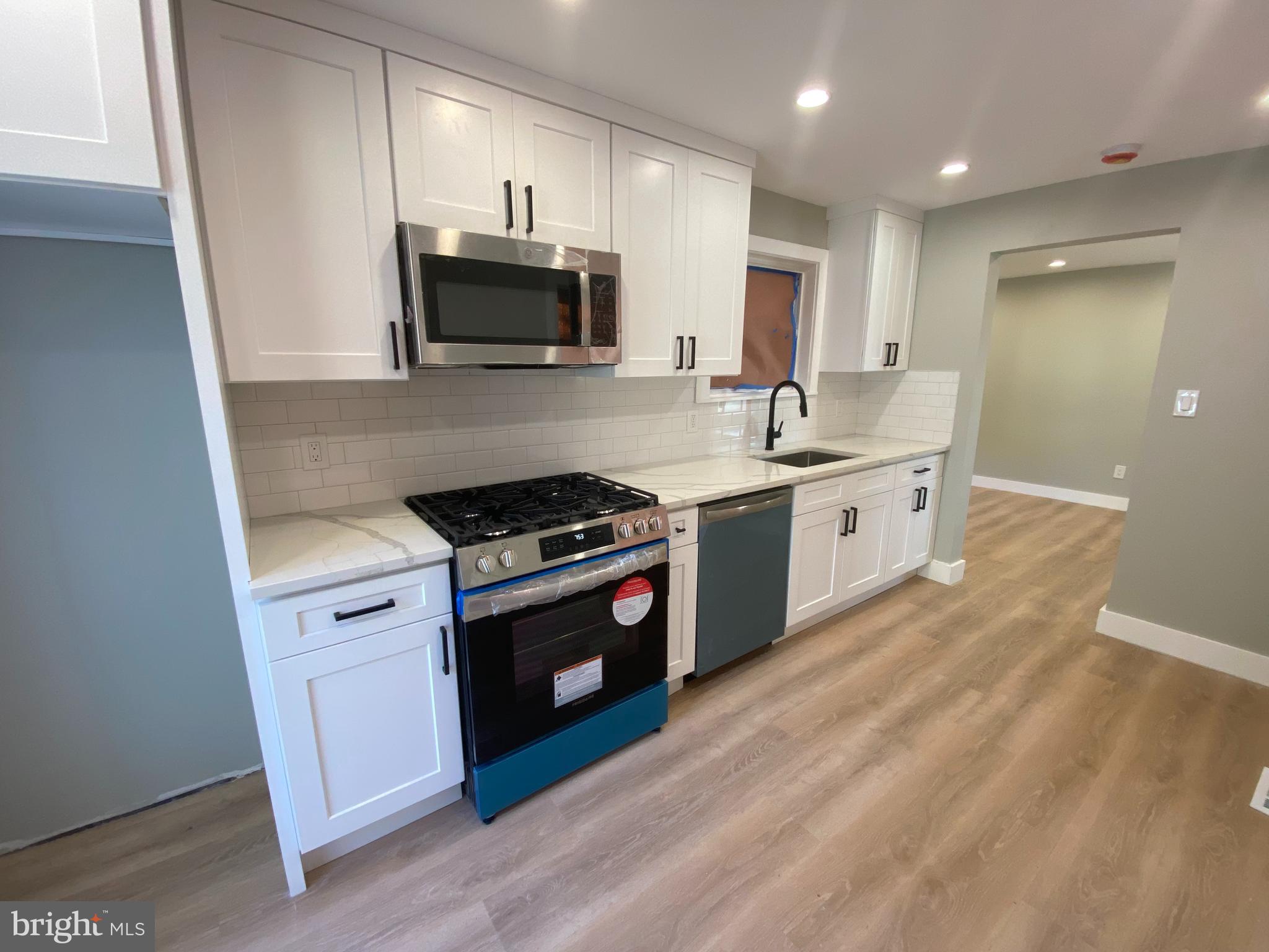 1104 Highway 77 Bridgeton, NJ 08302 - Photo 7 of 21 a kitchen with stainless steel appliances granite countertop a stove a sink and a microwave