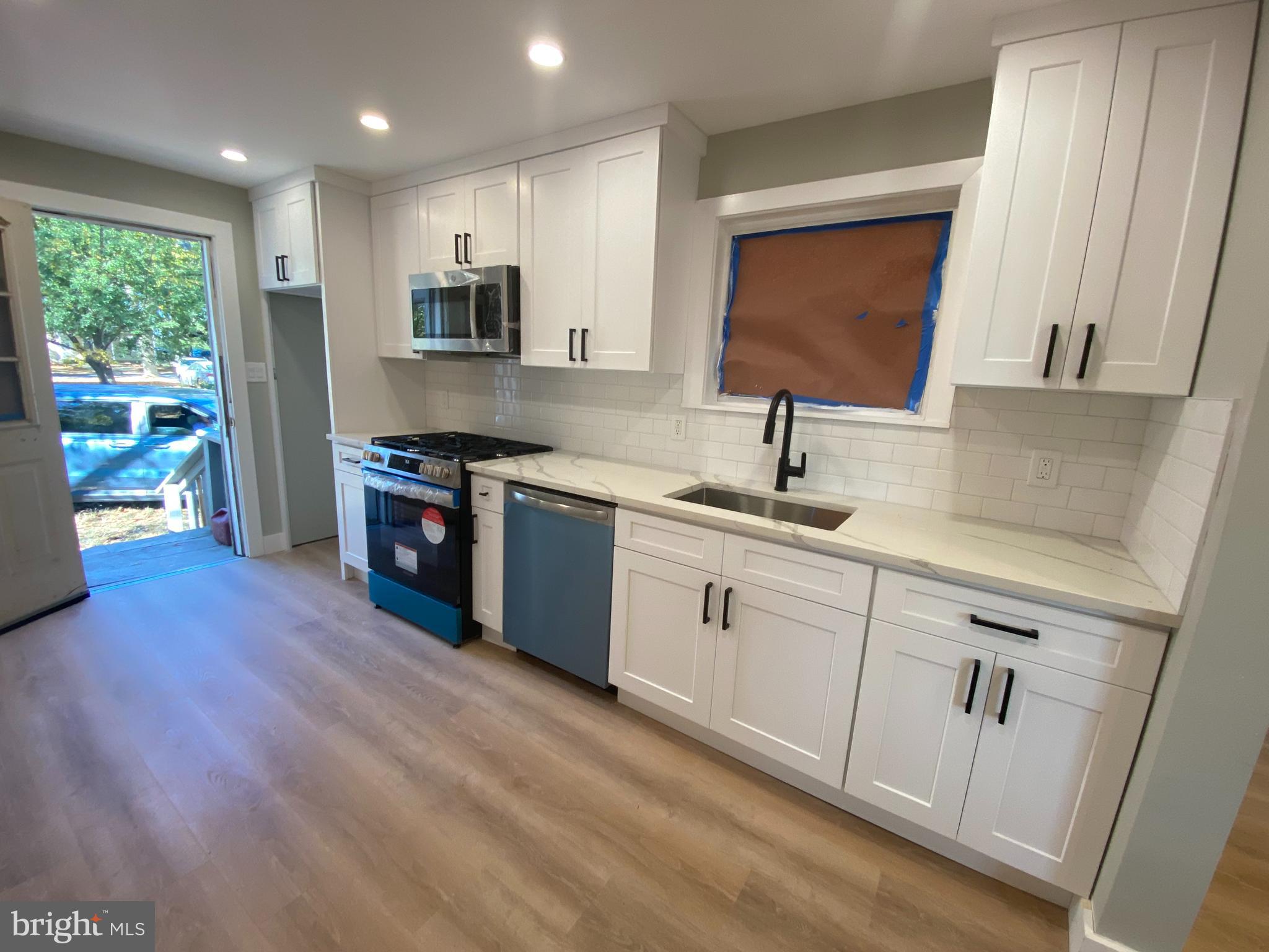 1104 Highway 77 Bridgeton, NJ 08302 - Photo 8 of 21 a kitchen with stainless steel appliances granite countertop a sink dishwasher stove and refrigerator with wooden floor