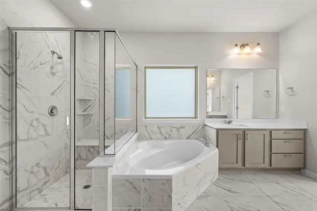 a spacious bathroom with a bathtub sink and mirror