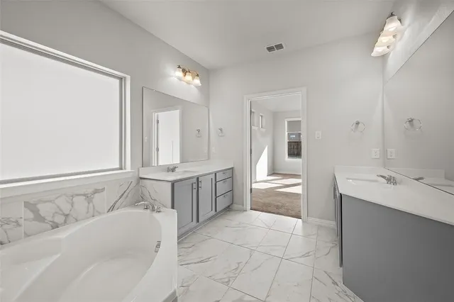 a bathroom with a bathtub sink and mirror