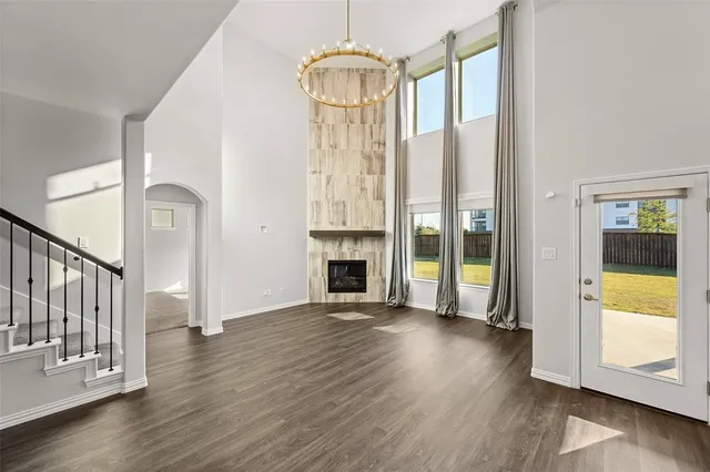 a view of a hallway with wooden floor fireplace and windows