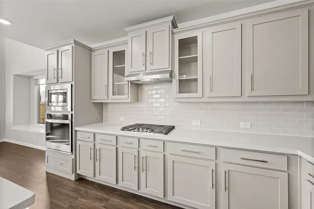 a kitchen with stainless steel appliances granite countertop white cabinets and sink