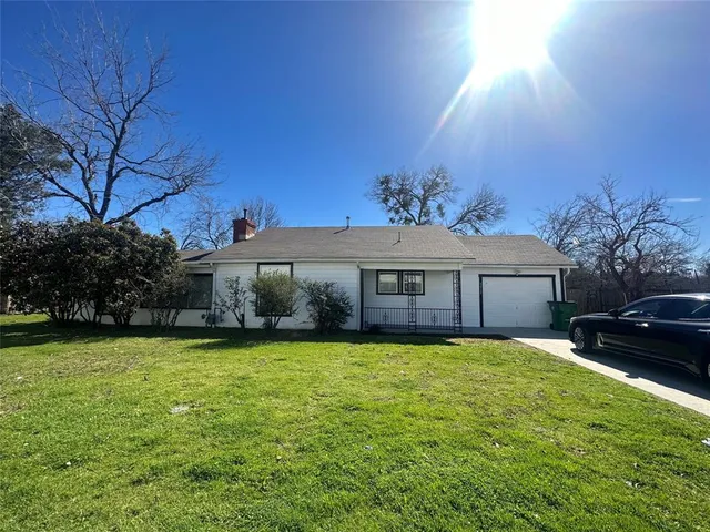 a view of a house with a yard and potted plants