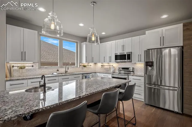 a kitchen with granite countertop a center island stainless steel appliances and cabinets