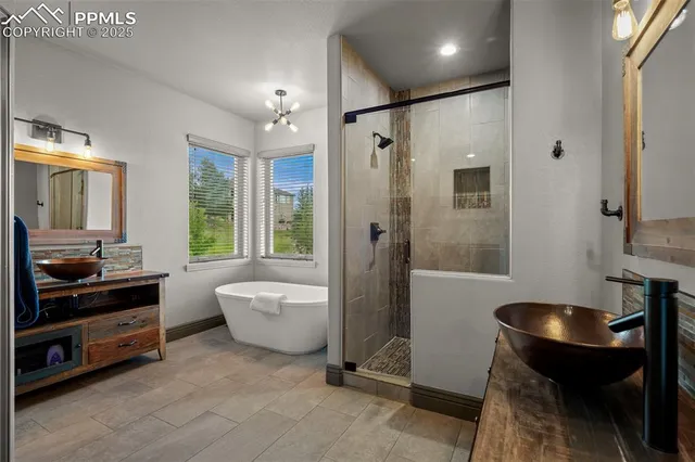 a bathroom with a tub a sink and a mirror
