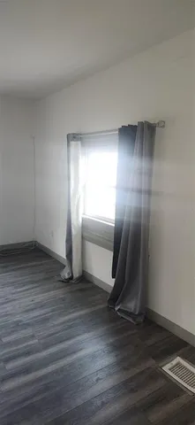 a view of a room with wooden floor