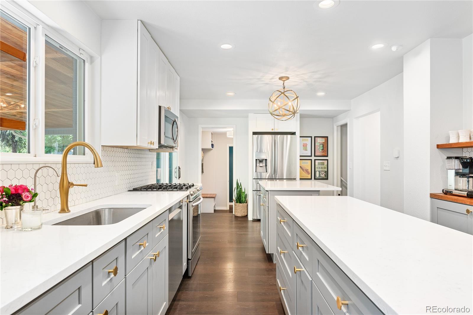 6149 South Elizabeth Way Centennial, CO 80121 - Photo 12 of 49 a large kitchen with kitchen island a sink a large window stainless steel appliances and cabinets