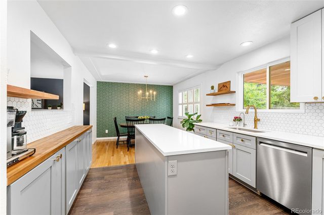 a kitchen with white cabinets appliances and a window