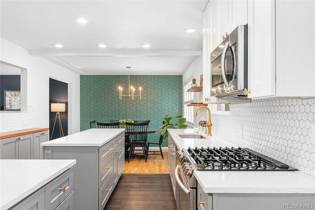 a kitchen that has a lot of cabinets in it and wooden floors