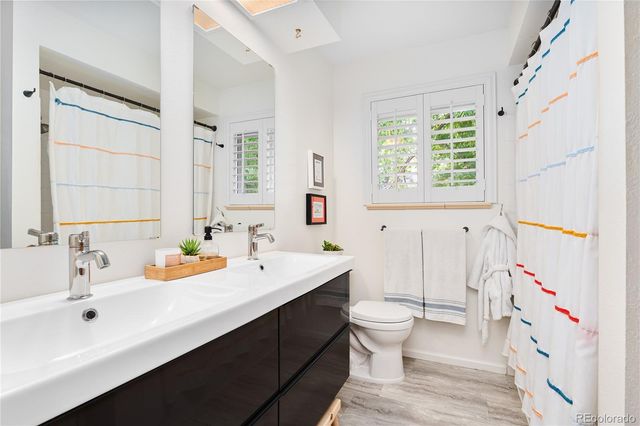 a bathroom with a sink a toilet and a large mirror