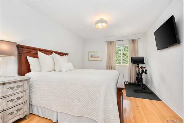 a bedroom with a bed and a flat tv screen on the dresser