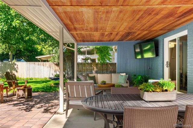 a view of a patio with furniture and a garden