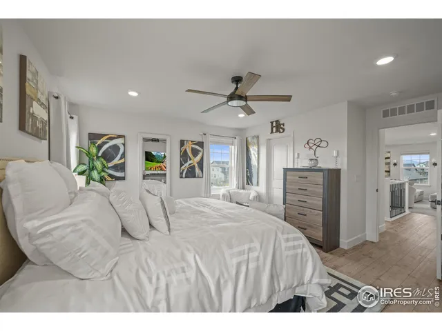 a bedroom with a bed and a flat tv screen on dresser