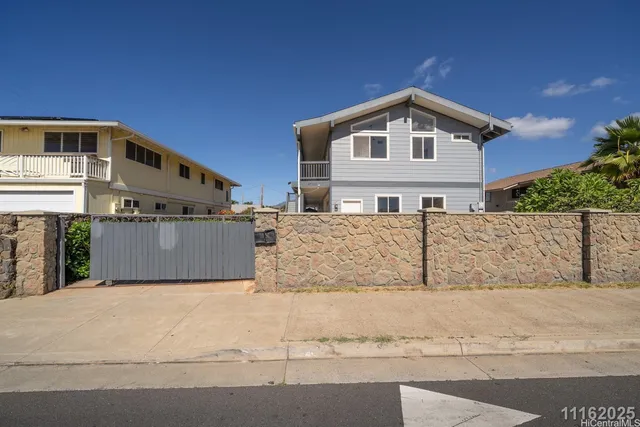 a front view of a house with large trees