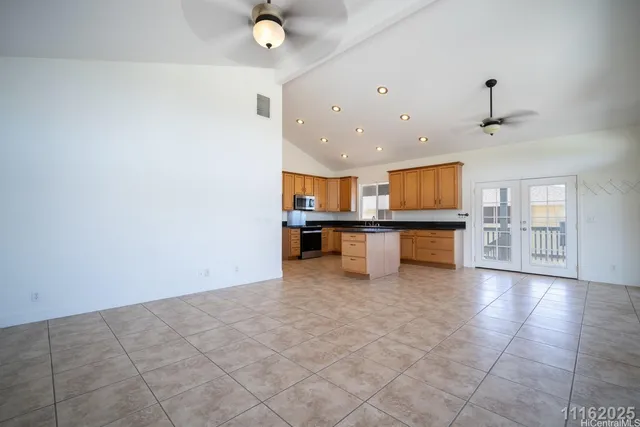 a large kitchen with granite countertop a large counter top stainless steel appliances and cabinets