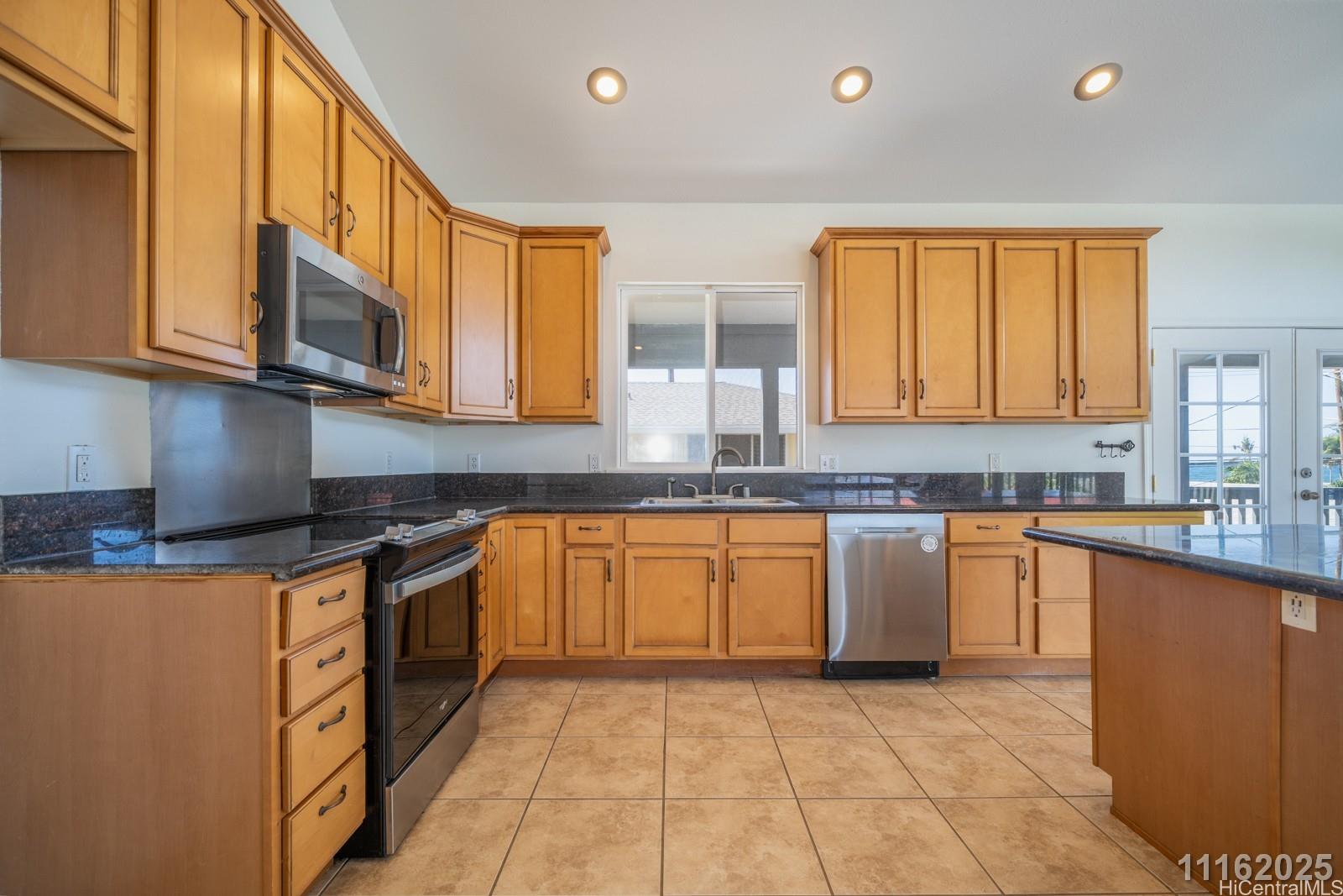 87-110 Kaukama Road, Unit B Waianae, HI 96792 - Photo 17 of 24 a kitchen with stainless steel appliances granite countertop a stove a sink and a microwave