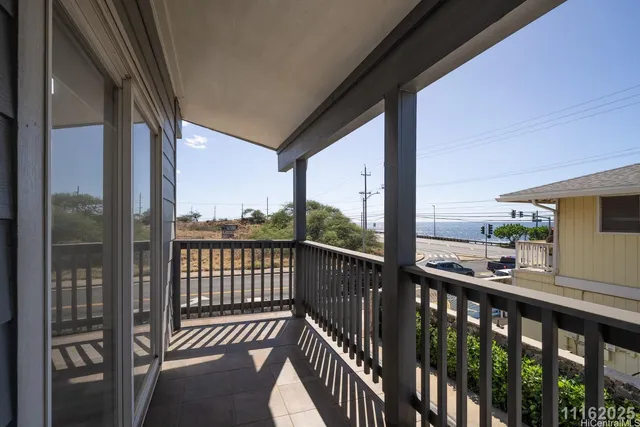 a view of a balcony with wooden floor and iron fence