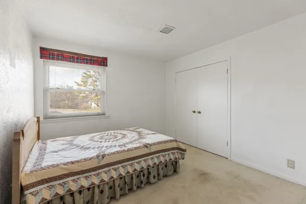 a bedroom with a bed and a window