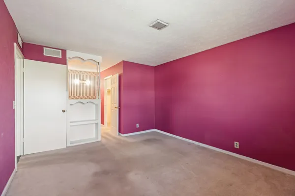 a view of a bedroom with a bed and a window