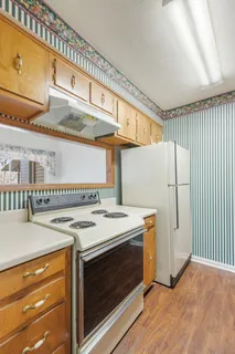 a kitchen with stainless steel appliances granite countertop a sink a stove and a wooden cabinets