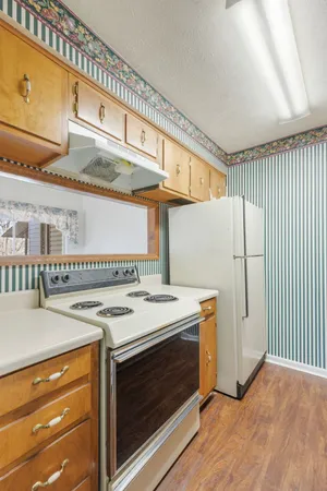 a kitchen with stainless steel appliances granite countertop a sink a stove and a wooden cabinets
