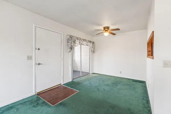 an empty room with closet and a chandelier fan