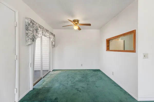 a view of a hallway with a chandelier fan and windows