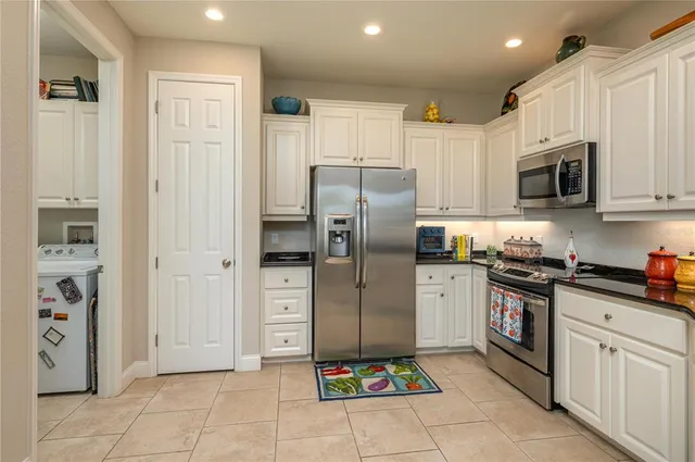 a kitchen with stainless steel appliances granite countertop a refrigerator and a stove top oven