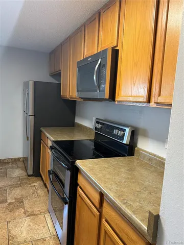 a kitchen with stainless steel appliances a stove a microwave and a refrigerator