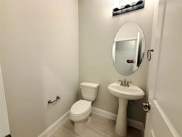 a bathroom with a toilet sink and mirror