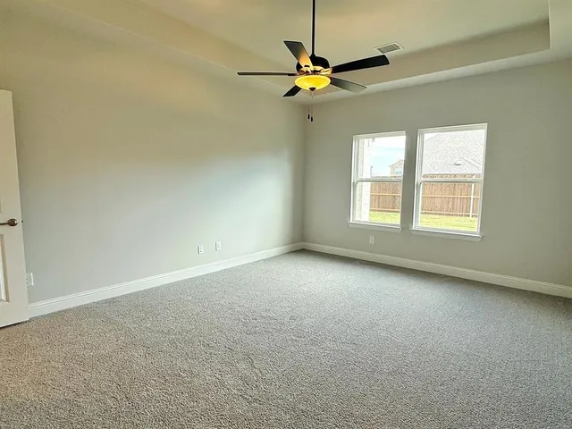 an empty room with a window and a fan