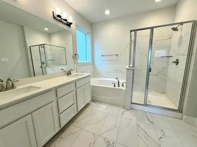 a bathroom with a double vanity sink mirror and shower