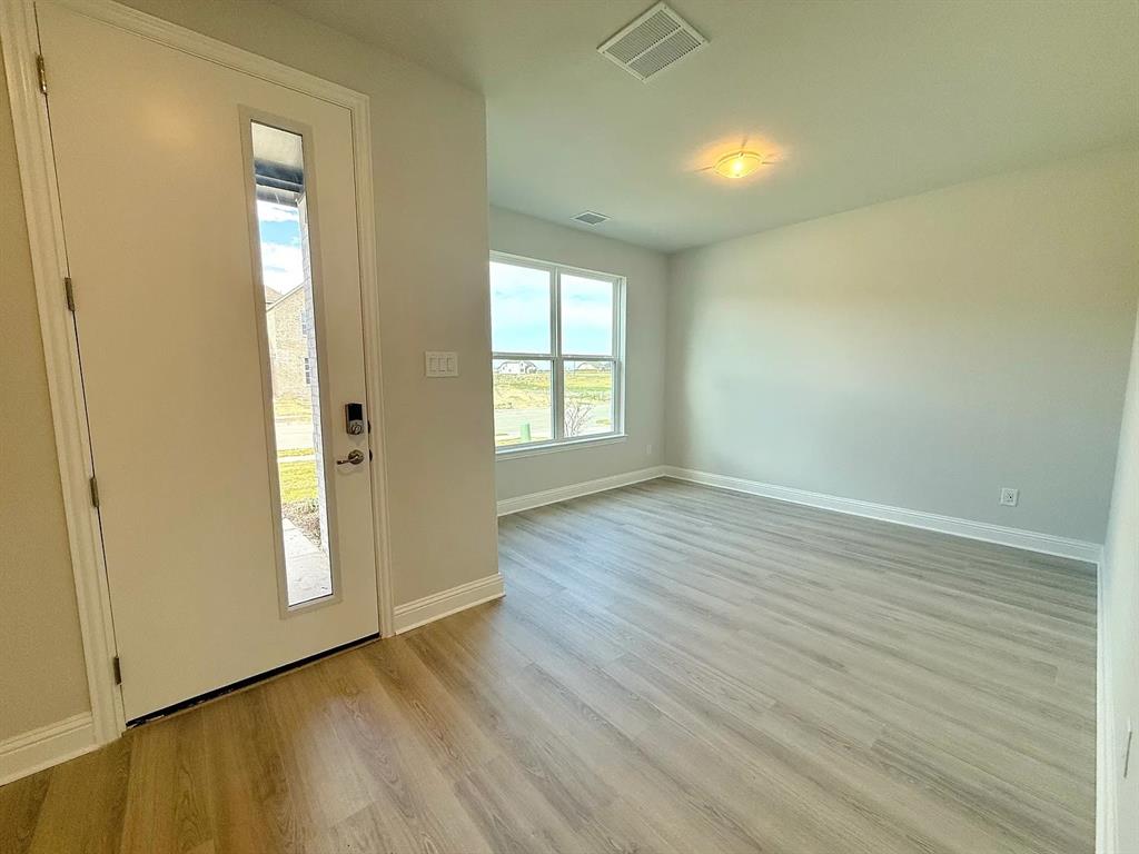 2708 Shiners Street Forney, TX 75126 - Photo 9 of 25 an empty room with wooden floor and windows