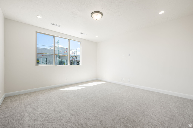 684 West High Tide Place, Unit 131 St. George, UT 84790 - Photo 19 of 27 Bright room featuring a three-panel window, light textured carpet, recessed lighting, and a flush-mount ceiling fixture