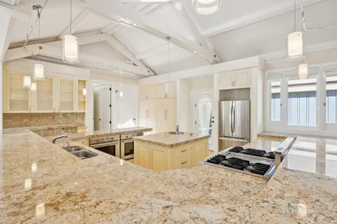 a large kitchen with a stove a sink and a refrigerator