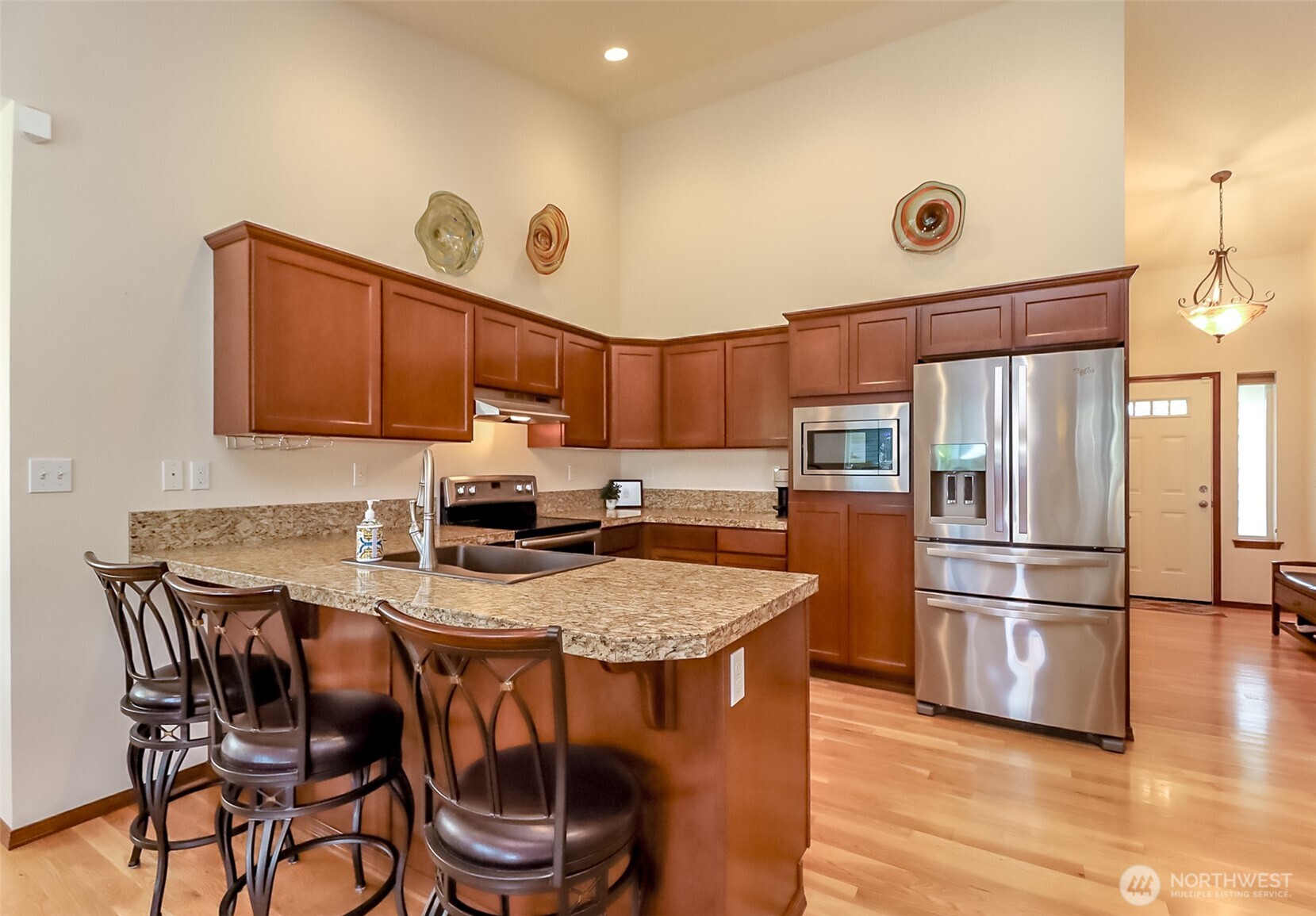 315 Dennis Way Monroe, WA 98272 - Photo 13 of 37 a kitchen with granite countertop a table chairs microwave and refrigerator