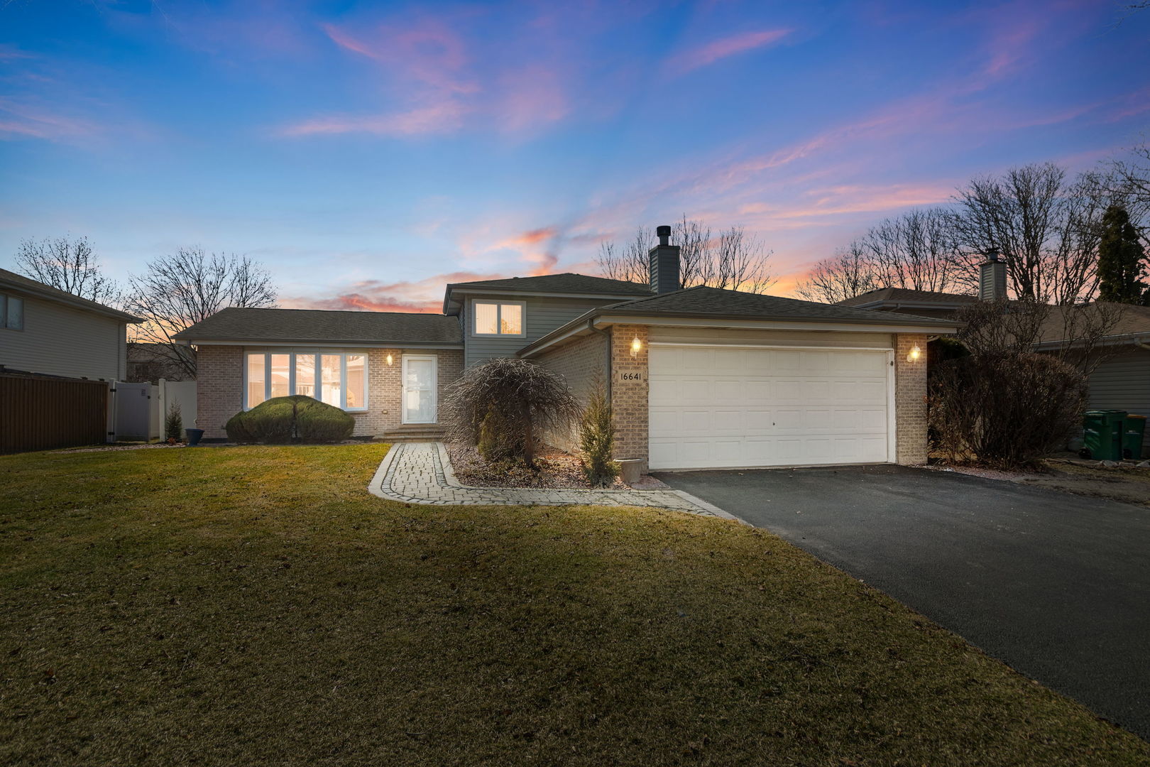 a front view of a house with a garden and yard