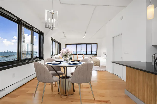 a dining room with furniture a chandelier and wooden floor