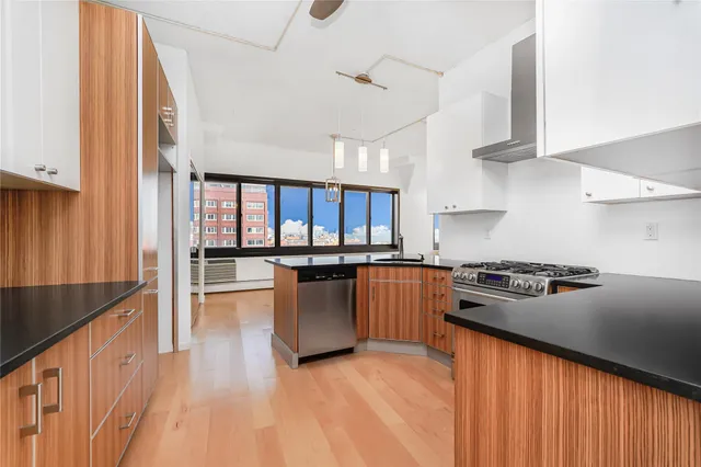 a kitchen with stainless steel appliances granite countertop a sink and a stove next to a white cabinet
