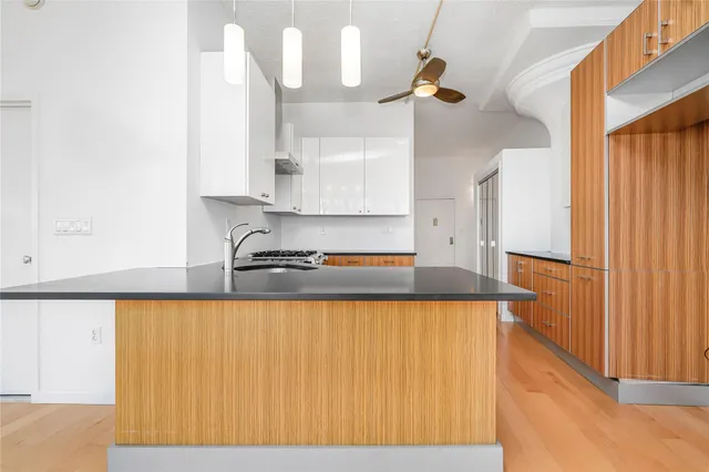 a kitchen with granite countertop a sink a refrigerator and a granite counter top