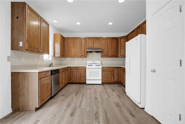 a kitchen with a refrigerator sink and cabinets