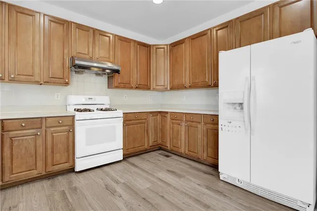 a kitchen with white cabinets and white appliances