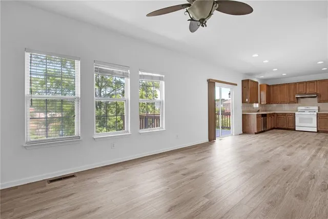 a view of empty room with wooden floor and window