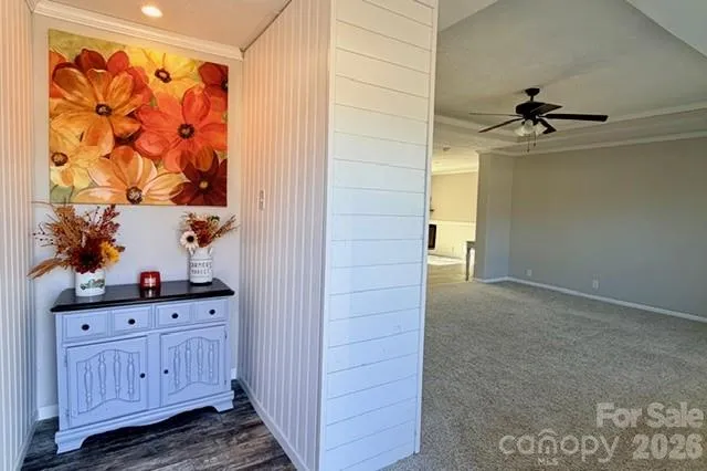 a view of a hallway with wooden floor and cabinet