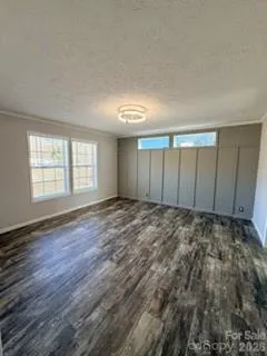 an empty room with wooden floor and window
