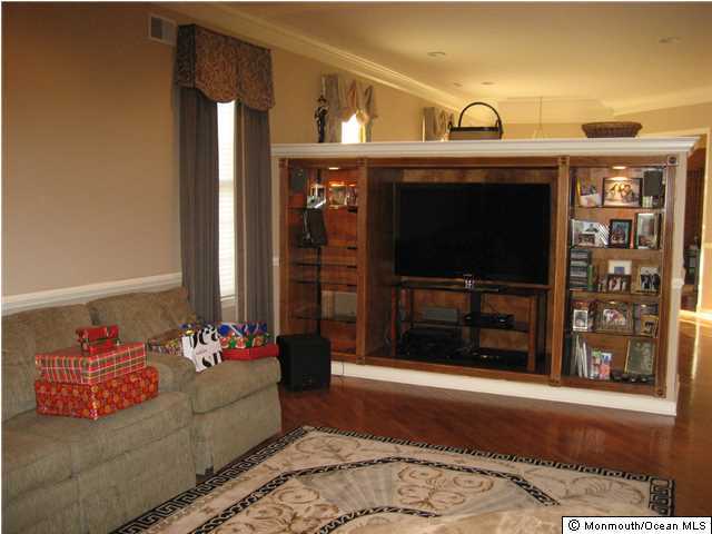 23 Shoal Road Jackson, NJ 08527 - Photo 5 of 21 a living room with furniture a flat screen tv and a fireplace