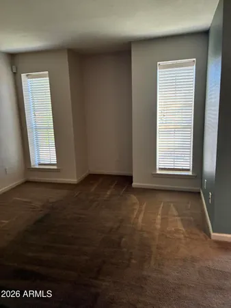a view of a room with a chandelier fan and windows