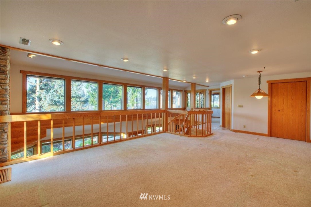 1822 Channel Road East Lake Tapps, WA 98391 - Photo 21 of 38 a big room with large windows and a chandelier