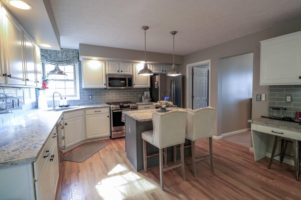 549 Dorchester Drive Seven Fields, PA 16046 - Photo 6 of 35 a kitchen with a dining table chairs appliances and a counter top space
